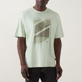 Model wearing Hugo Boss Orange Te Journey Relaxed Fit T-Shirt in Open Green with abstract graphic print, styled with dark jeans