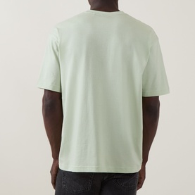 Model wearing Hugo Boss Orange Te Journey Relaxed Fit T-Shirt in Open Green, back view showing dropped shoulders and relaxed fit, styled with dark
