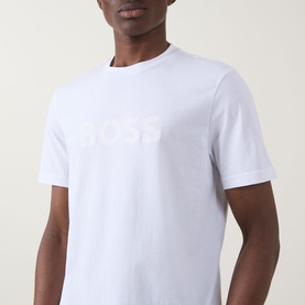 Model wearing Hugo Boss Orange Te Logo T-Shirt in white with tonal BOSS chest logo, crew neck and short sleeves.