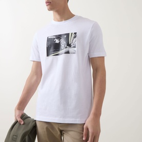 Model wearing Hugo Boss Orange Te Motors Logo Graphic T-Shirt in white with motor graphic print. Styled with khaki trousers.