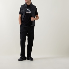 Model wearing Hugo Boss Orange black crew neck T-shirt, styled with quilted gilet, black cargo trousers and chunky trainers.