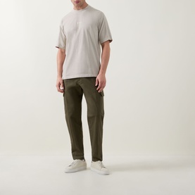 Model wearing Hugo Boss Orange Light Beige crew neck cotton T-shirt, styled with khaki cargo trousers and white trainers.
