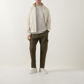 Model wearing Hugo Boss Orange Light Beige crew neck T-shirt, styled with cream zip jacket, khaki cargo trousers and white trainers.