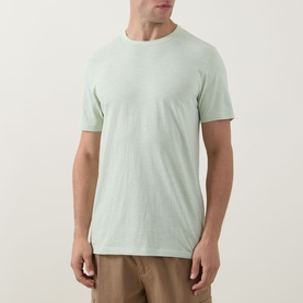 Model wearing Hugo Boss Orange Open Green cotton crew neck T-shirt, styled with tan trousers.
