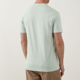 Model wearing Hugo Boss Orange Open Green cotton crew neck T-shirt, shown from rear, styled with tan trousers.
