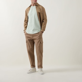 Model wearing Hugo Boss Orange Open Green crew neck T-shirt, styled with tan overshirt, matching cargo trousers and white trainers.