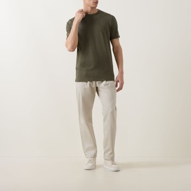Model wearing Hugo Boss Orange Bright Green cotton crew neck T-shirt with stone chinos and white trainers.