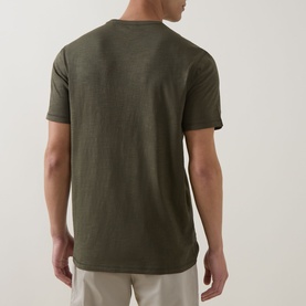 Model wearing Hugo Boss Orange Bright Green crew neck cotton T-shirt, back view, styled with beige trousers.