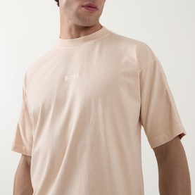 Model wearing Hugo Boss Orange crew neck T-shirt in light pastel orange, with small chest logo, relaxed oversized fit in 100% cotton