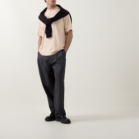 Model wearing Hugo Boss Orange light pastel orange cotton crew neck T-shirt, styled with dark trousers, black loafers and draped scarf.