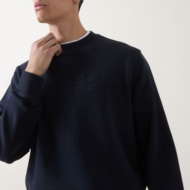 Model wearing Hugo Boss Orange dark blue cotton crew neck sweatshirt with tonal embossed logo, styled with white crew neck underneath.
