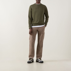 Model wearing Hugo Boss Orange Westart Logo Sweater in Bright Green with beige cargo trousers and chunky trainers.