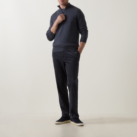Model wearing Hugo Boss Orange Kanobix Half-Zip Sweater in dark blue, styled with navy trousers and grey suede trainers.