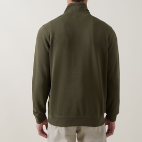 Model wearing Hugo Boss Orange Bright Green cotton half-zip sweatshirt, shown from behind, styled with light beige trousers.