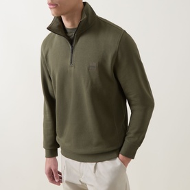 Model wearing Hugo Boss Orange Bright Green cotton half-zip sweatshirt with funnel neck and logo patch, styled with white trousers