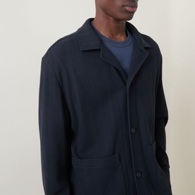 Model wearing Hugo Boss Carper Stripe Overshirt in dark blue, tonal stripe texture, flat collar, button fastening and patch pockets, styled with navy
