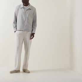 Model wearing Hugo Boss light beige virgin wool jacket with white tee, cream trousers and beige suede loafers