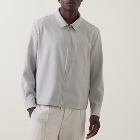Model wearing Hugo Boss light beige wool zip-through jacket with point collar, styled with matching tailored trousers