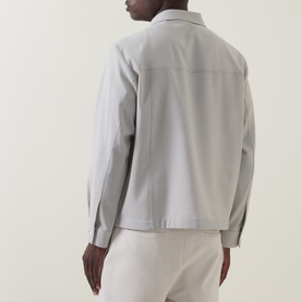 Model wearing Hugo Boss light beige 100% virgin wool jacket, back view, styled with cream trousers