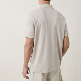 Model wearing Hugo Boss Orange light beige cotton polo shirt, rear view, paired with matching casual trousers