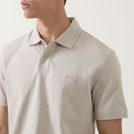 Model wearing Hugo Boss Orange light beige cotton polo shirt with tonal logo embroidery and short sleeves, three-button placket visible