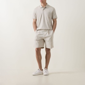 Model wearing Hugo Boss Orange light beige cotton polo shirt, styled with matching shorts and white trainers