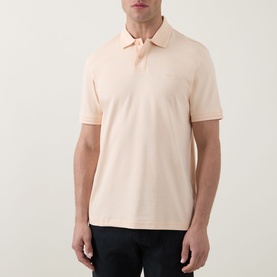Model wearing Hugo Boss Orange polo shirt in light pastel orange, short sleeves, classic collar, slim fit cotton piqu&eacute;.