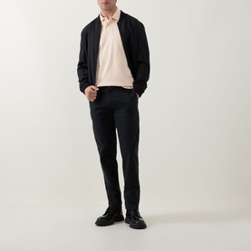 Model wearing Hugo Boss Orange Light Pastel Orange cotton polo, styled with navy bomber jacket, navy trousers, and black leather shoes.