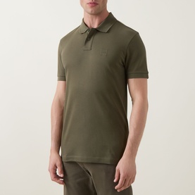 Model wearing Hugo Boss Orange Bright Green cotton polo shirt with tonal chest logo and ribbed collar, styled with khaki trousers