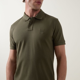 Model wearing Hugo Boss Orange Bright Green cotton polo shirt with tonal logo patch and three-button placket