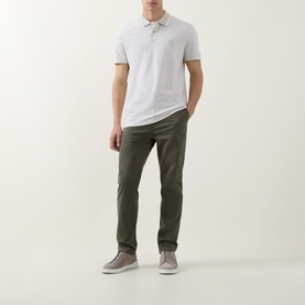 Model wearing Hugo Boss Orange Passerford Tipped Logo Polo Shirt in Light Beige with tipped collar, styled with olive chinos and grey trainers.