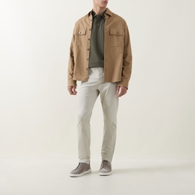 Model wearing Hugo Boss Orange Passerford Tipped Logo Polo Shirt in Bright Green, styled with beige overshirt, light grey trousers and grey suede