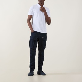 Model wearing Hugo Boss Orange Passertip Logo Polo Shirt in White with navy cargo trousers and dark trainers.