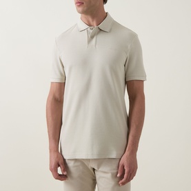 Model wearing Hugo Boss Orange light beige cotton polo shirt with short sleeves and two-button placket, styled with matching chinos
