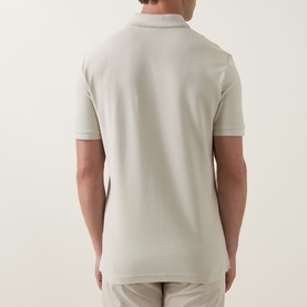 Model wearing Hugo Boss Orange light beige cotton polo shirt, rear view showing short sleeves and ribbed collar
