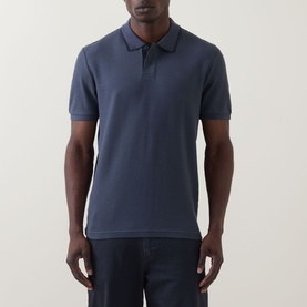 Model wearing Hugo Boss Orange Phoenix Logo Tipped Polo Shirt in dark blue, with tonal tipped collar trim and short sleeves, styled with dark jeans.
