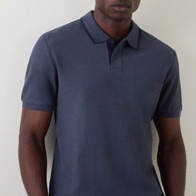 Model wearing Hugo Boss Orange Phoenix Logo Tipped Polo Shirt in dark blue, showing polo collar, button fastenings and short sleeves.