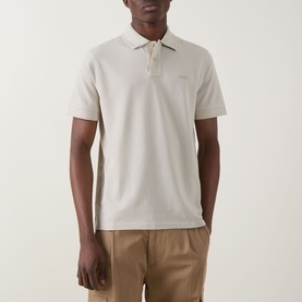 Model wearing Hugo Boss Orange Prime Logo Polo Shirt in Light Beige, with two-button placket and tonal chest logo, styled with tan trousers.