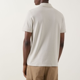 Model wearing Hugo Boss Orange Prime Logo Polo Shirt in light beige, back view, styled with tan chinos. Short sleeves, straight hem.