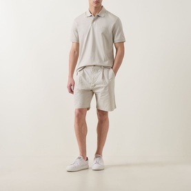 Model wearing Hugo Boss Orange light beige cotton shorts with white trainers and a matching beige polo shirt.