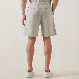 Model wearing Hugo Boss Orange light beige cotton shorts with elasticated waist and rear patch pocket, styled with white trainers.