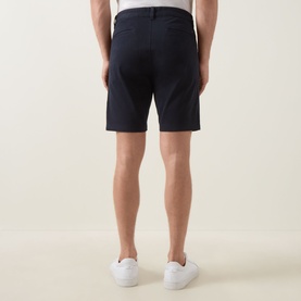 Model wearing Hugo Boss Orange dark blue cotton shorts, rear view, styled with white trainers