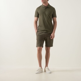 Model wearing Hugo Boss Orange Bright Green cotton shorts with matching polo shirt and white trainers.