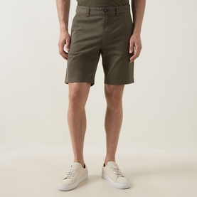 Model wearing Hugo Boss Orange Bright Green cotton chino shorts, styled with white low-top trainers.