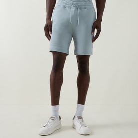 Model wearing Hugo Boss Orange Open Grey cotton drawstring shorts, styled with white socks and white trainers.