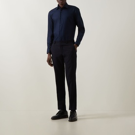Model wearing Hugo Boss Hank K Single-Cuff Shirt in dark blue with spread collar and sateen finish, styled with navy trousers and black shoes.