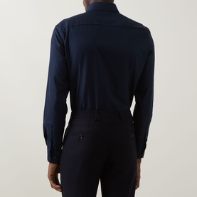 Model wearing Hugo Boss Hank K Single-Cuff Shirt in dark blue, rear view showing slim fit, buttoned cuffs and curved hem, styled with navy trousers