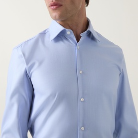 Model wearing Hugo Boss light blue slim fit formal shirt in 100% cotton, featuring spread collar and single button placket detail.