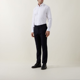 Model wearing Hugo Boss Joe Classic Shirt in white with kent collar, styled with navy tailored trousers and black leather shoes.