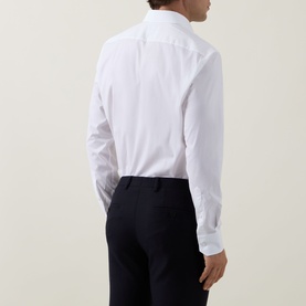 Model wearing Hugo Boss Joe Classic Shirt in white, back view, paired with navy tailored trousers. Kent collar and long sleeves visible.